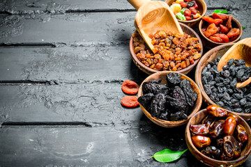Assortment of different types of dried fruits in bowls.