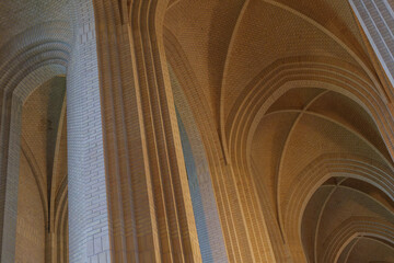 Detail of cream brick vault, arch, rib wall, column and clerestory element on the ceiling of...