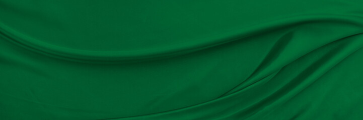 Black green satin dark fabric texture luxurious shiny that is abstract silk cloth background with...