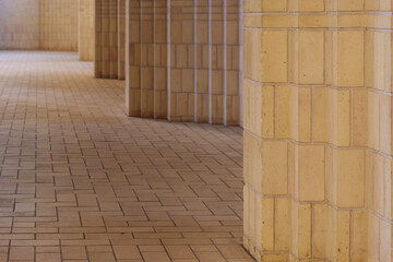 Low angle and selective focus view of cream brick floor, wall and column of expressionist protestant church. 