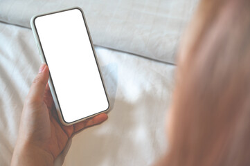 Close up relax women using a smartphone with an empty white screen lazy on the bed at home.