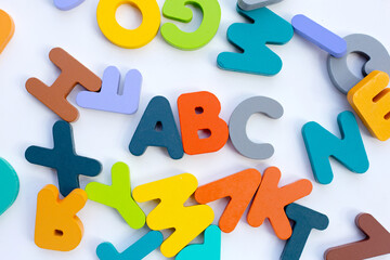 Colorful wooden alphabets on white background.