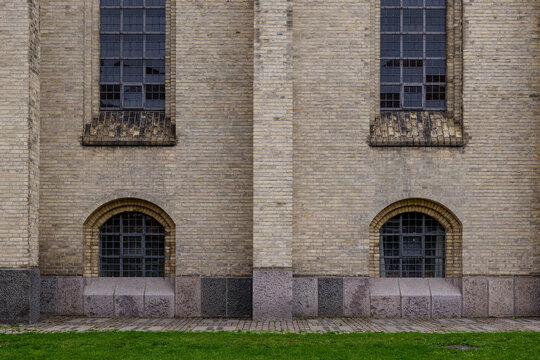 Outdoor Exterior Side Of Rough Brick Facade, Arch Detail Windows And High Windows Of Protestant Church.