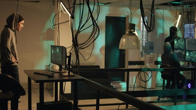 Cyber criminals working on breaking network system, using hacktivism concept to steal data. People committing cyberattack and identity theft, making privacy threats. Tripod shot.