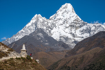 Fototapeta na wymiar Tourist standing at the edge of the hill and looking to beautiful view of Mt.Ama Dablam (6,812 m). Ama Dablam is one of the most beautiful mountains in the world.