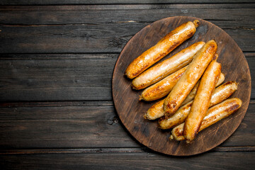 Grill beef sausages on a round Board.