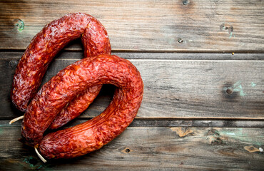 Fragrant salami on wooden background.
