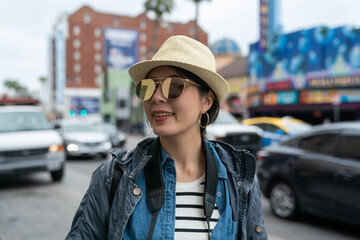 young Asian female traveler smiling walking on the street