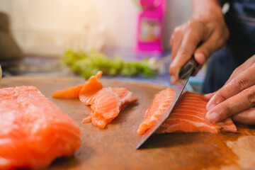 Closeup of Human hands cooking salmon menu in kitchen at home. 