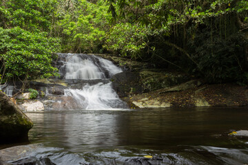 Naklejka premium Cachoeira do Paquetá - ILHABELA, SP, BRAZIL - NOVEMBER 28, 2022: Paqueta waterfall photographed with a long exposure time to cause the bridal veil effect.
