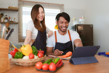 Portrait of young asian couple making salad together at home. cooking food and Lifestyle moment and healthy