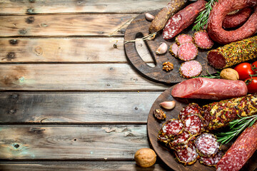 Various types of salami on a Board with nuts.