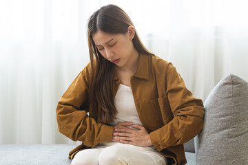 Flatulence asian young woman hand in stomach ache, suffer from food poisoning, abdominal pain and...