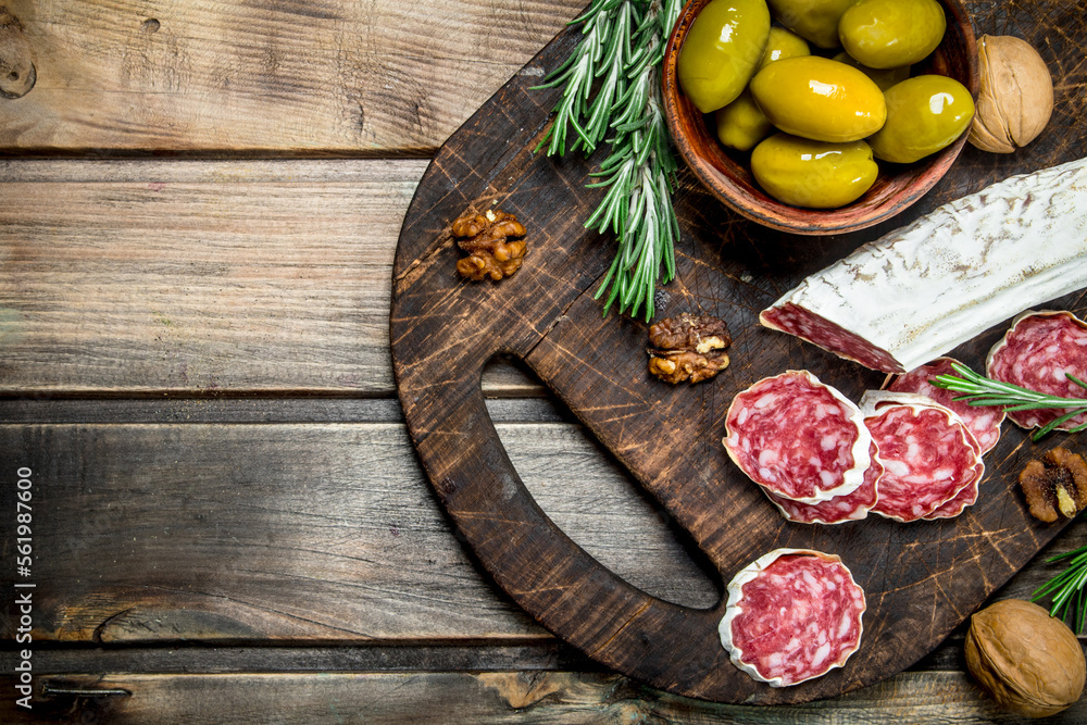 Wall mural Salami with olives and a sprig of rosemary