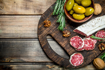 Salami with olives and a sprig of rosemary