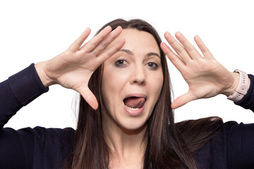 Portrait of a beautiful young woman with her hands up next to her face and pulling her tongue out