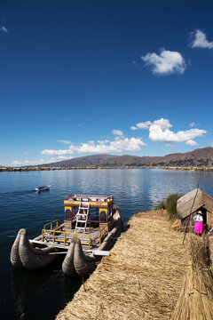 Uros, Peru - Jan 5, 2019. Traditional Totora boat with tourists on Titicaca lake near to the Uros floating islands , Puno, Peru, South America.