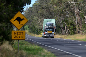 Fototapeta na wymiar Watertank carried on a country road with signage warning of kangaroos