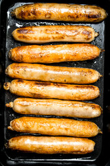 Fried sausages on a baking sheet.