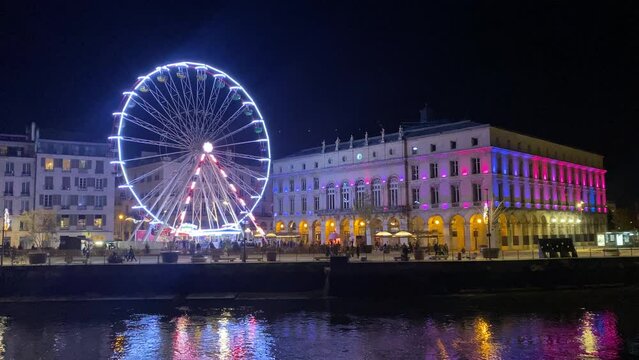 This stock video showcases an impressive view of the Ferris wheel in the beautiful city of Bayona, illuminated by Christmas lights. The river stretches out in the background,