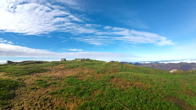 Drone footage of summit of Monte Adi in Navarra. Low altitude flight shows mesmerizing blue and green tones of landscape. Perfect for adventure and outdoor content.