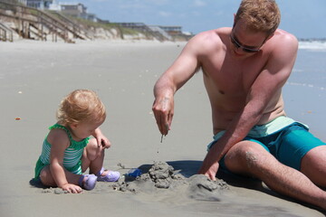 man and baby play in sand at Myrtle Beach South Carolina