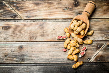 Fototapeta premium Peanuts in a wooden scoop .