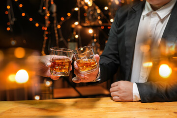 food and drink male friends are happy drinking beer and clinking glasses at a bar or pub.