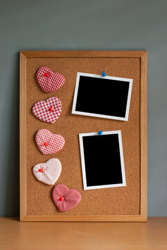 Five hearts shaped with two blank instant photos mounted on a corkboard, Valentines day concept.