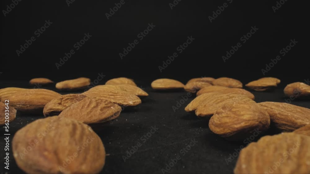 Poster scattered lightly roasted unsalted almonds. the camera passes in between. dolly shot with macro prob