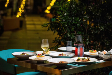 Romantic Dinner for couple at Outdoor Restaurant with dishes and glasses of champagne