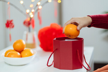 Asian Woman holding mandarin oranges with red gift box thankful present Lunar New Year. Chinese...