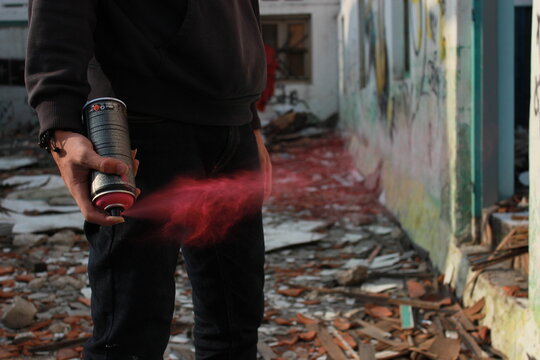 Photo of man spraying pink aerosol paints