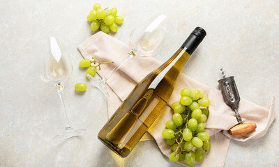Glasses and bottle with white wine on a white background.