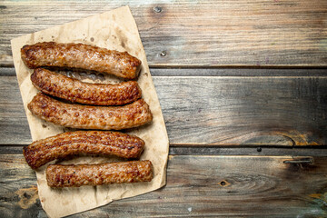 Grill sausages on paper .