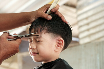 Cute Little Asian Thai Boy cutting hair.