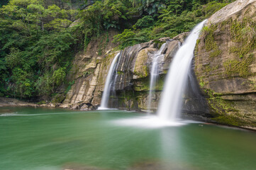 Fototapeta premium Small but beautiful waterfalls, clear streams, big rocks and green trees. Lingjiao Waterfall, Pingxi District, New Taipei City, Taiwan