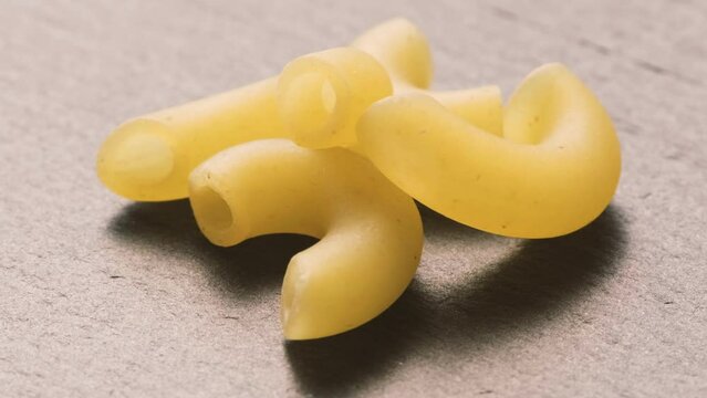 Close up uncooked macaroni pasta falling. 