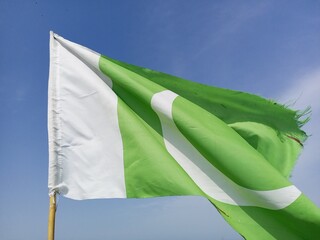 Pakistani flag waving in the wind with blue sky background