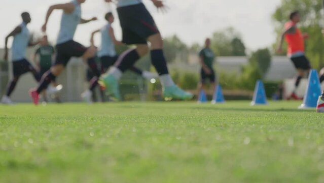Low angle slow motion shot of out focus soccer players jogging