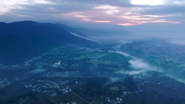 Wide aerial footage of the sunrise and fog in the early morning on the outskirts of San Juan Ostuncalco.
