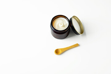 Obraz na płótnie Canvas Cosmetic cream in a jar with a spoon