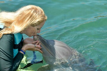 woman kissing dolphin 