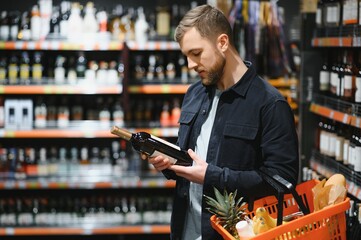 Man in a supermarket choosing a wine