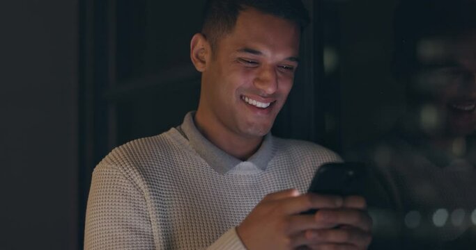 Smartphone, night and business man typing on mobile app for global chat, funny notification or social media. Happy corporate worker using phone or cellphone in dark office for digital communication