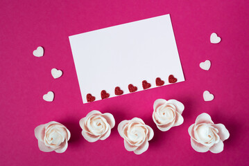 White sheet for text with hearts and roses on a pink background.