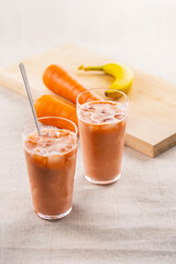 Banana and Carrot smoothie on a table.
fresh smoothie image.
