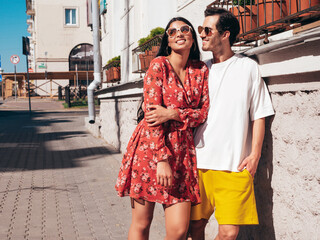 Naklejka premium Smiling beautiful woman and her handsome boyfriend. Happy cheerful family. Sexy couple posing in the street at sunrise. During romantic date at sunny summer day outdoors. Looking at each other
