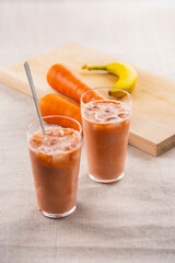 Banana and Carrot smoothie on a table.
fresh smoothie image.
