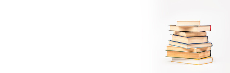 A stack of books on a light background. The concept of reading a paper book, learning.